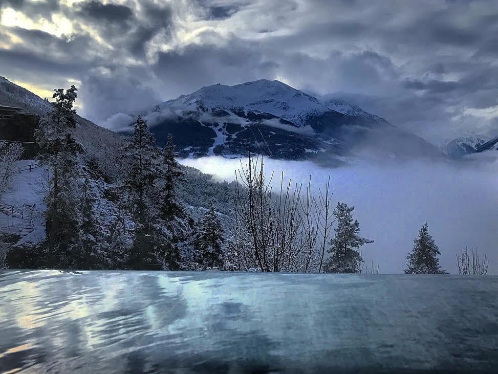 Una piscina termale all'aperto immersa nel paesaggio dolomitico del Trentino