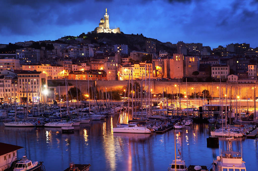Il porto vecchio di Marsiglia con le barche ormeggiate e la basilica di Notre-Dame de la Garde sullo sfondo