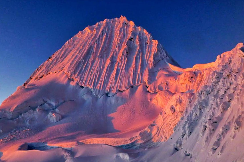 La vetta innevata dell'Alpamayo sulle Ande peruviane con cielo azzurro