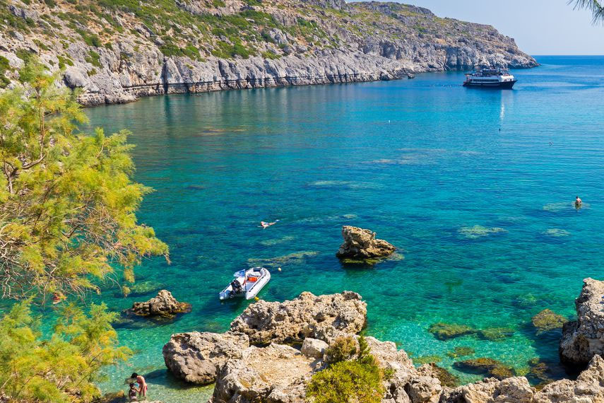 Lettino sotto una palma su una spiaggia caraibica con mare turchese sullo sfondo