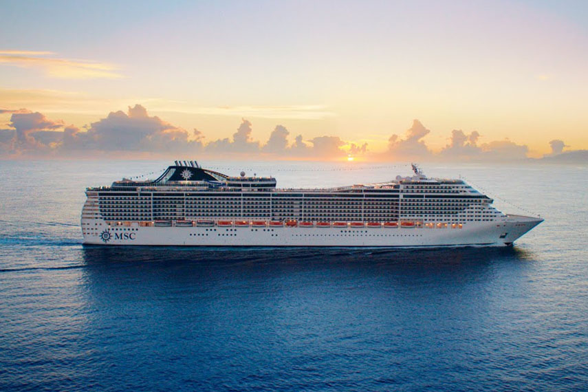 Una grande nave da crociera in navigazione su un mare azzurro al tramonto