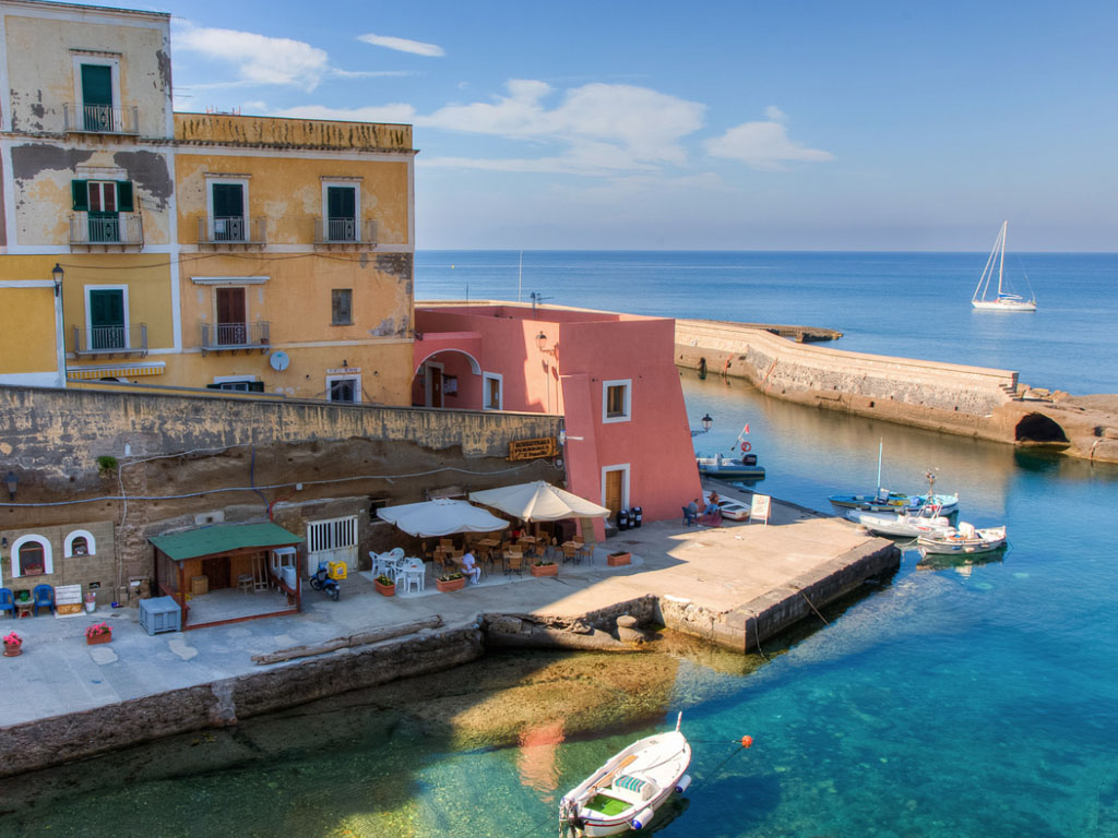 La costa rocciosa di Ventotene con il porto romano e il mare cristallino delle Isole Pontine