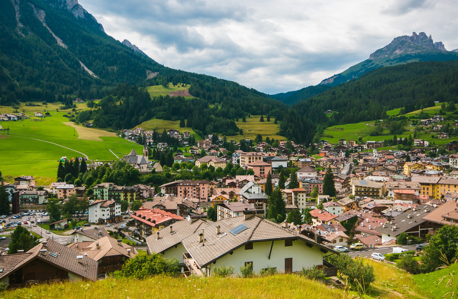 Il borgo di Moena tra i prati e le cime delle Dolomiti in Trentino Alto Adige
