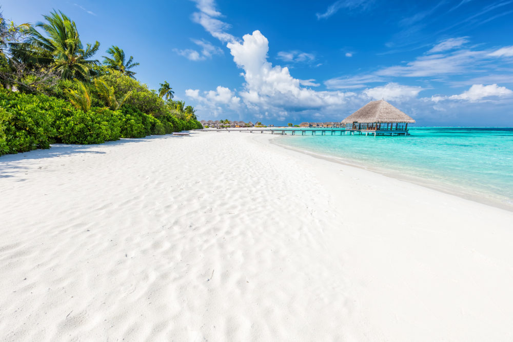 Bungalow sull'acqua turchese e spiaggia bianca di un atollo delle Maldive