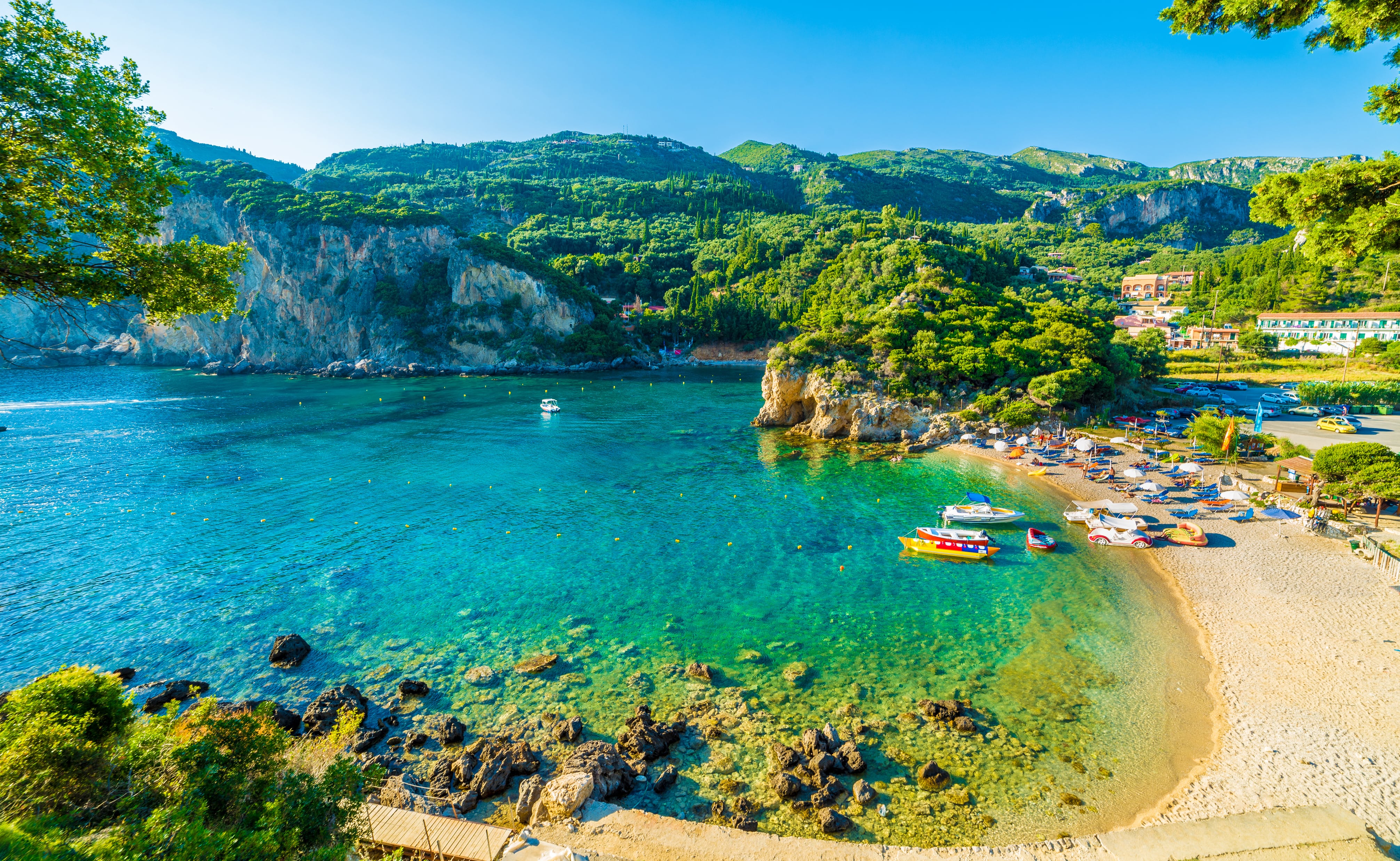 Baia con acque turchesi e vegetazione verde lungo la costa dell'isola di Corfù